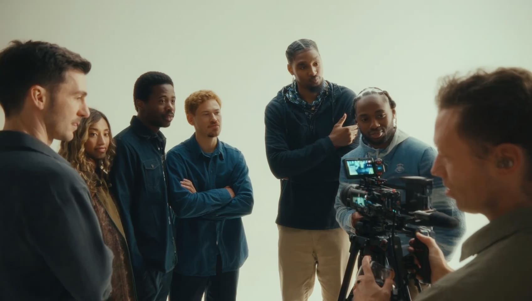 Director reviewing a take with on-camera talent beside a cinema camera in a bright studio