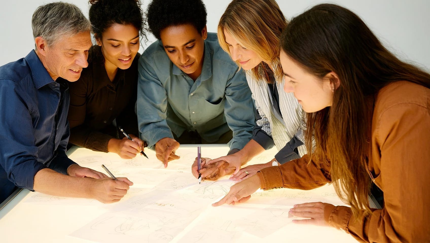 Copywriter and art director sketching campaign headlines together on a light table