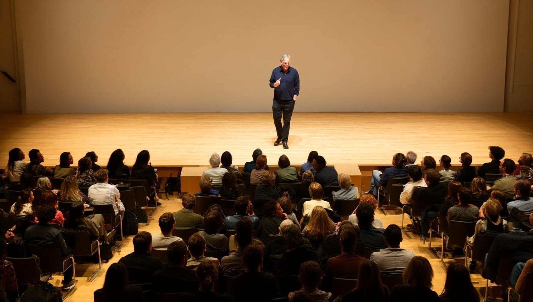 JULY speaker on an open stage addressing a full audience during a marketing seminar