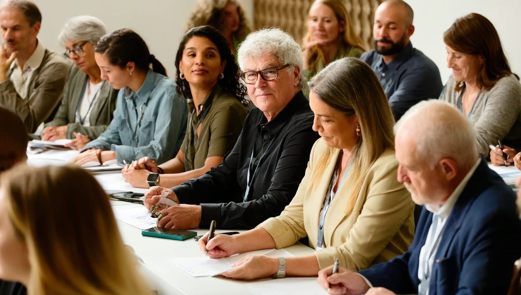 Workshop attendees taking notes at a table during a marketing seminar session